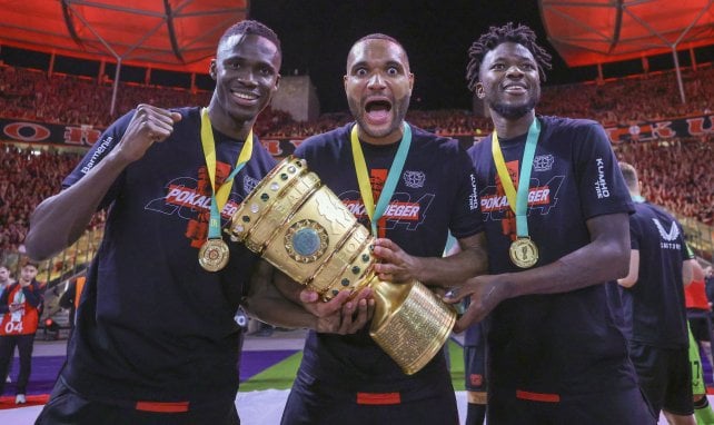 Odilon Kossounou (l.), Jonathan Tah (m.) und Edmond Tapsoba (r.) feiern den Pokalsieg