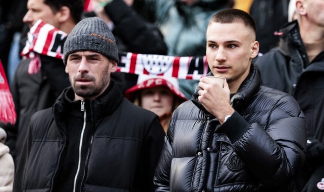 Philipp Pentke und Tim Lemperle (r.) verfolgen ein Spiel des 1. FC Köln von der Tribüne aus.
