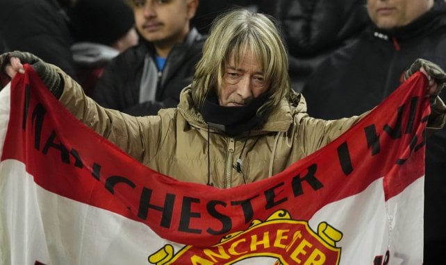 Eine enttäuschte Supporterin von Manchester United packt ihre Fahne ein